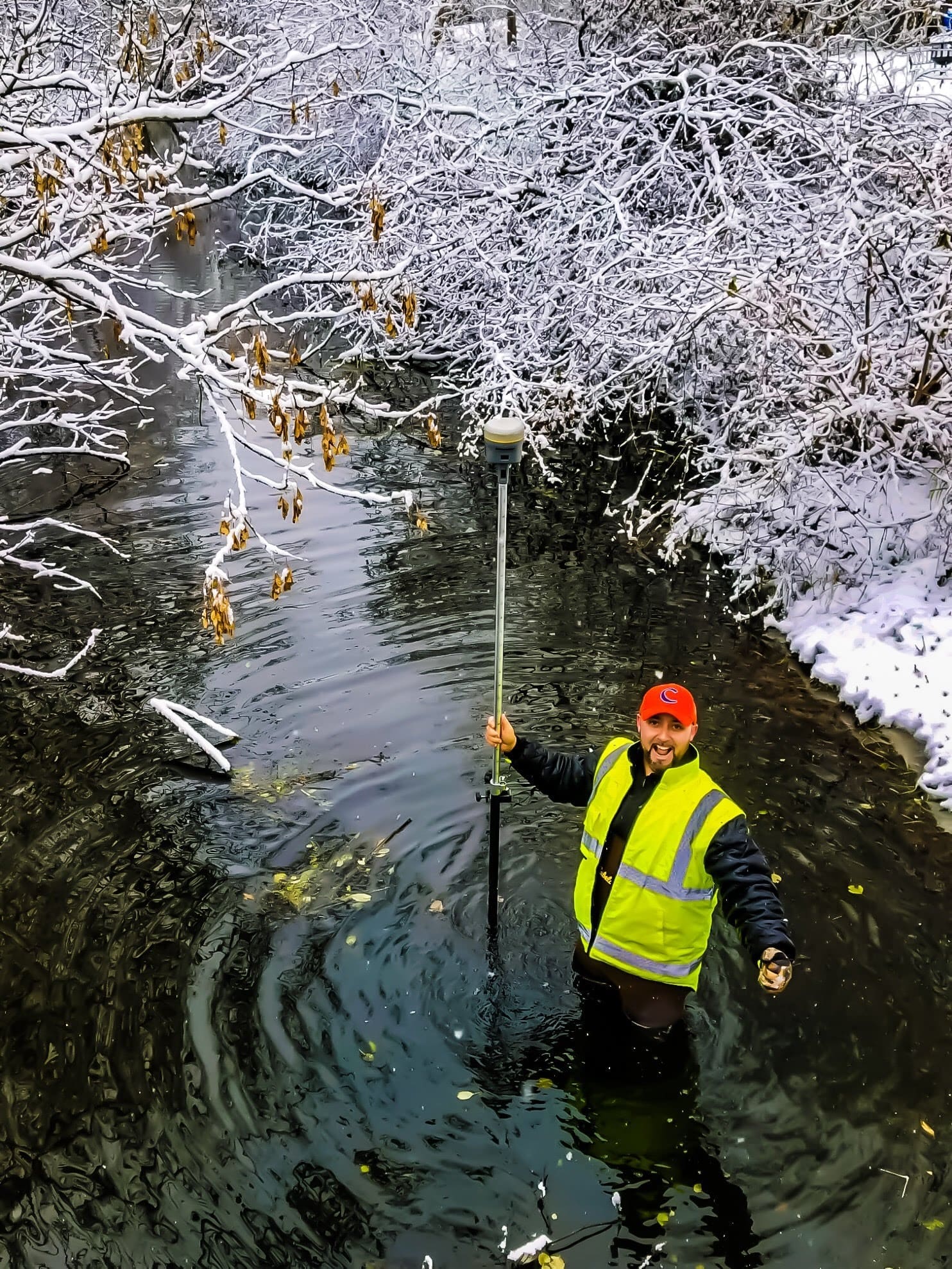 Surveyor wades in water at jobsite