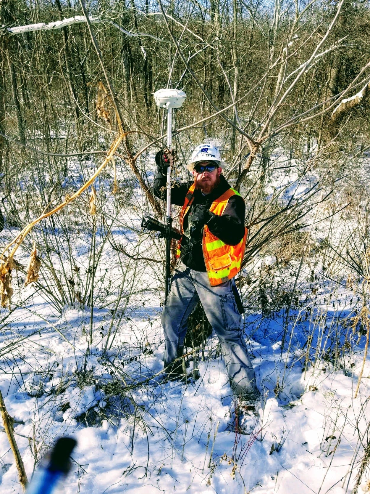 Surveyor uses equipment in snowy landscape